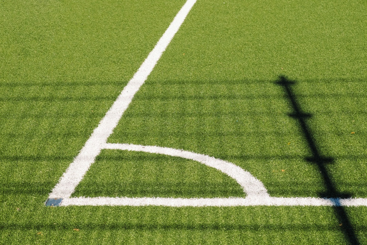 Soccer field corner with precise line markings and maintained artificial turf surface